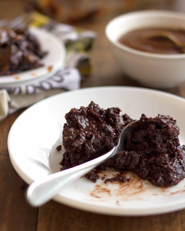 Chocolate caramel cake on a white plate.
