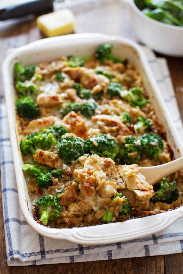 Chicken Quinoa and Broccoli Casserole being dished out with a wooden spoon.