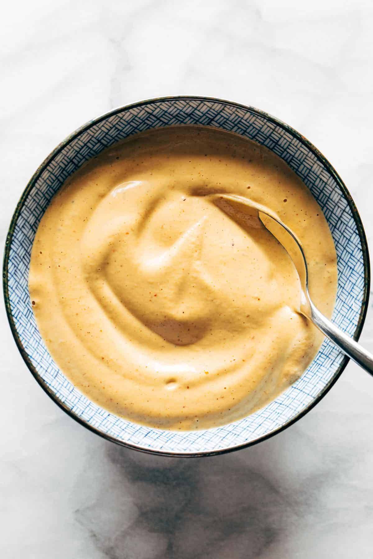 Chipotle cashew queso in a bowl with a spoon.