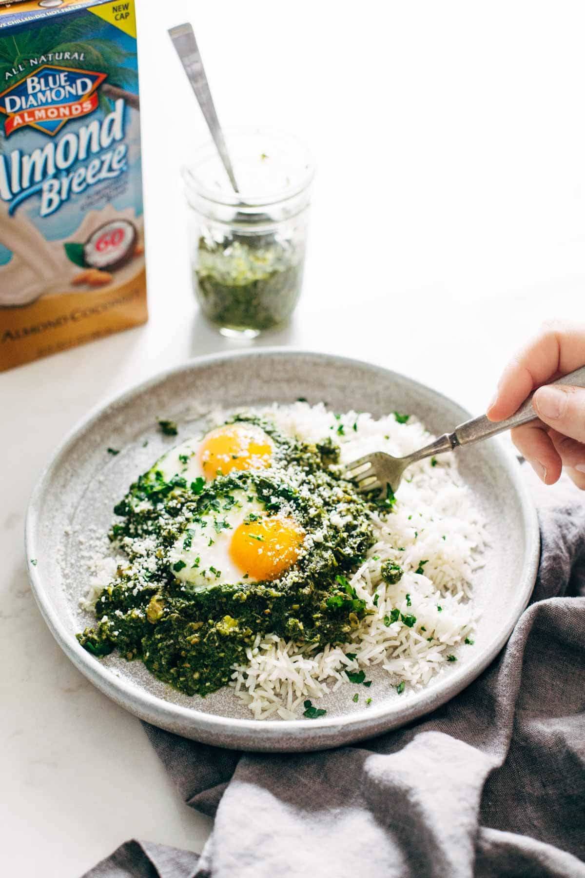 green shakshuka with rice on a plate with a fork and almond breeze