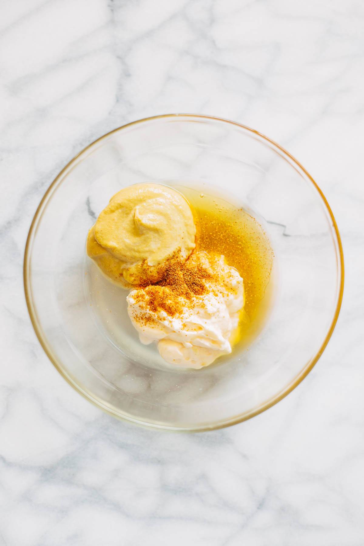 Ingredients for honey mustard sauce in a bowl.