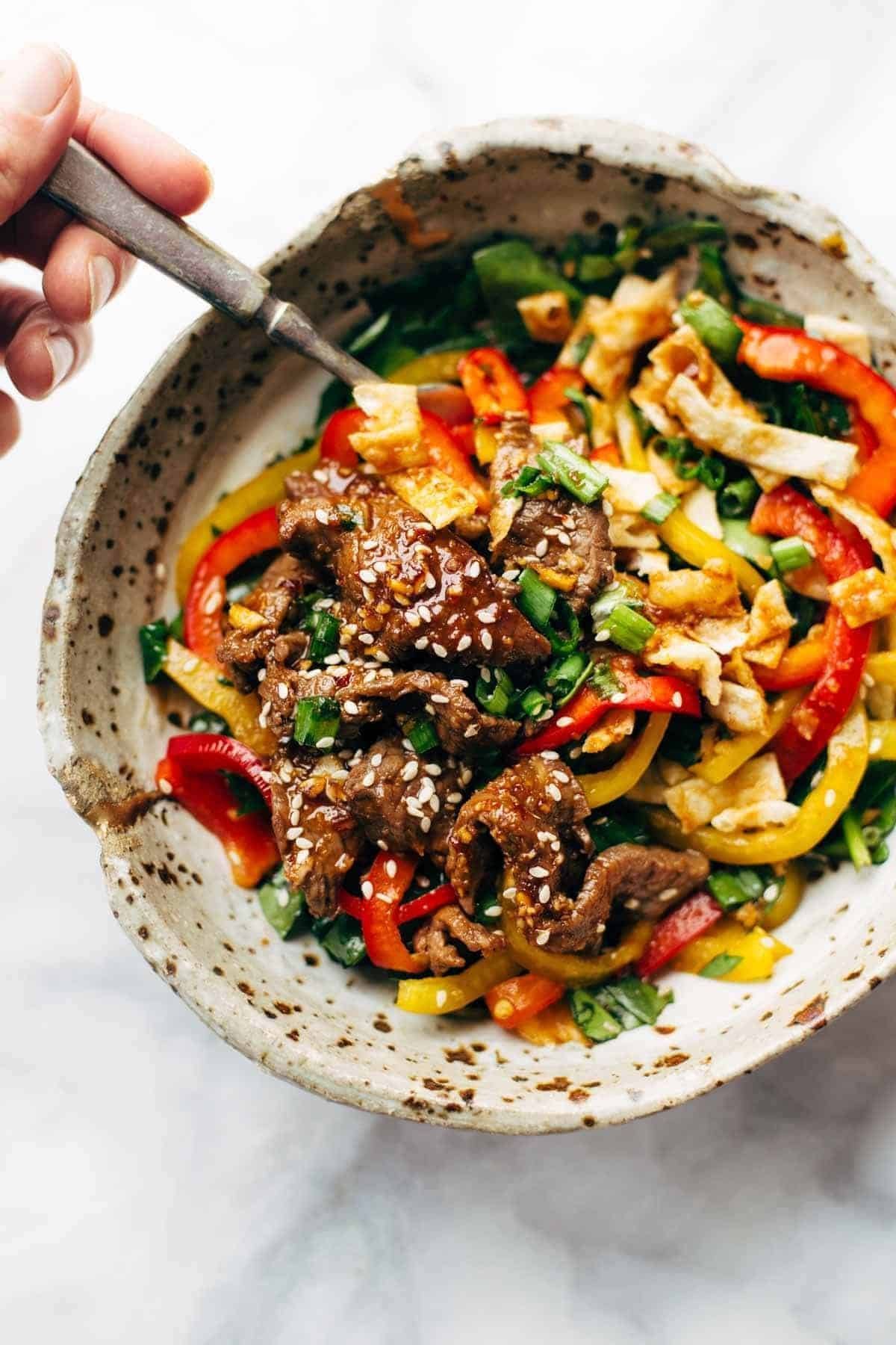 Korean BBQ Steak Bowls! Featuring Korean BBQ steak, bell peppers, scallions, greens, wonton strips, a spicy sesame ginger dressing. | pinchofyum.com Korean BBQ Steak Bowls! Featuring Korean BBQ steak, bell peppers, scallions, greens, wonton strips, a spicy sesame ginger dressing. | pinchofyum.com
