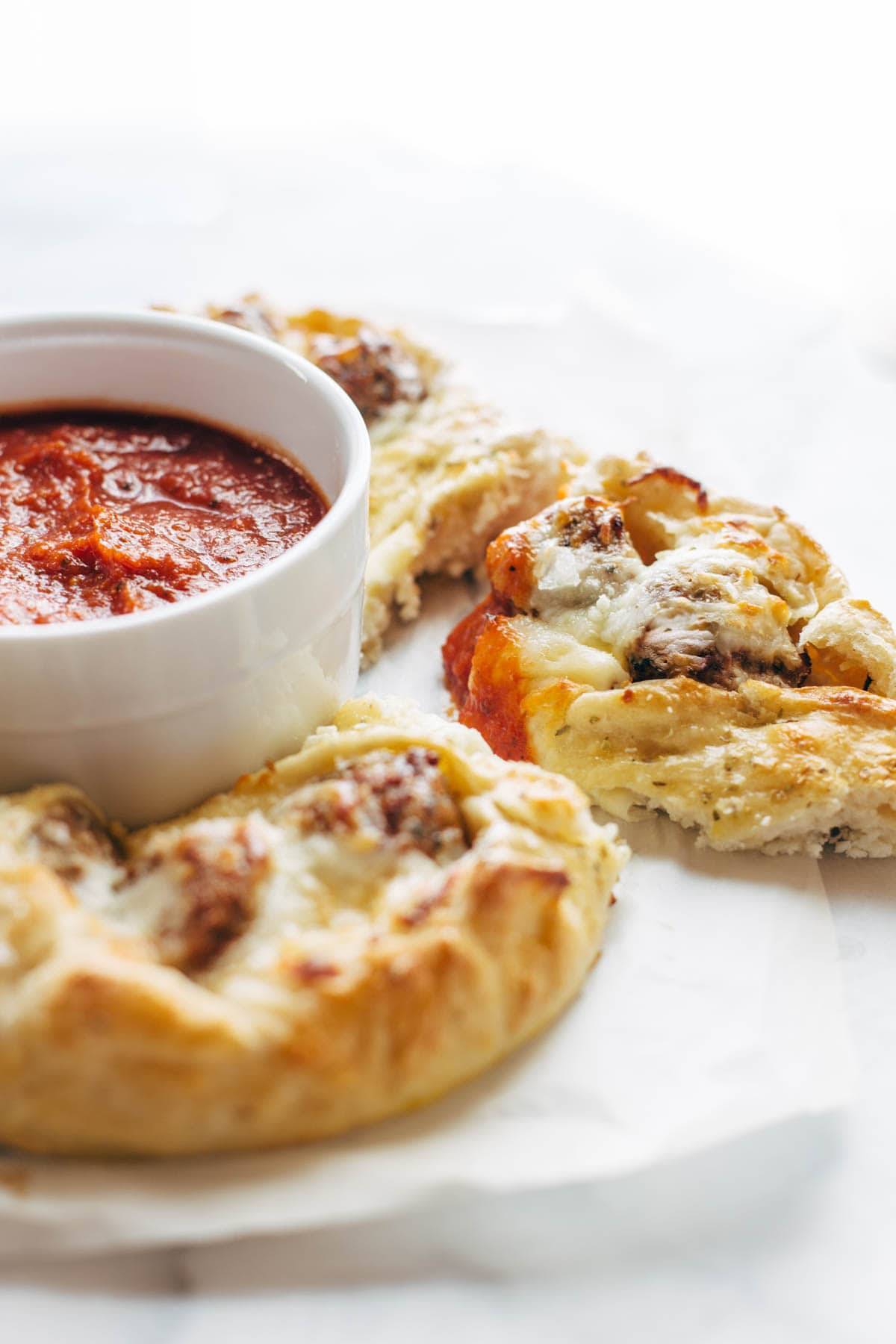 Cheesy Meatball Pull-Apart Pizza Ring with a bowl of marinara sauce